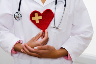 Doctor holding heart with bandage