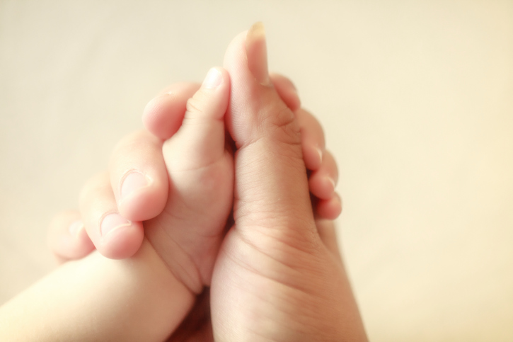 baby holding his mothers finger, selective focus
